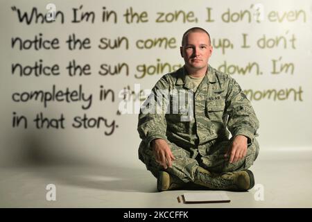 A U.S. Air Force Airman sitting on the floor with the writing of a fictional short story in the background. Stock Photo
