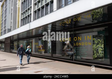 LONDON, UNITED KINGDOM - APRIL 11, 2021: people walk past John Lewis department store in Oxford Street as businesses get ready to open their premises to customers from tomorrow after being closed for over three months under coronavirus lockdown, on 11 April, 2021 in London, England. From Monday 12 April the next stage of lifting lockdown restrictions goes ahead with pubs and restaurants allowed to serve food and drinks outdoors, opening of non-essential shops, hairdressers, beauty salons and gyms in England. (Photo by WIktor Szymanowicz/NurPhoto) Stock Photo