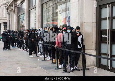 LONDON, UNITED KINGDOM - APRIL 12, 2021: Shoppers queue outside Nike store on Oxford Street as shops open their premises to customers after being closed for over three months under coronavirus lockdown, on 12 April, 2021 in London, England. From today the next stage of lifting lockdown restrictions goes ahead with pubs and restaurants allowed to serve food and drinks outdoors, opening of non-essential shops, hairdressers, beauty salons and gyms in England. (Photo by WIktor Szymanowicz/NurPhoto) Stock Photo