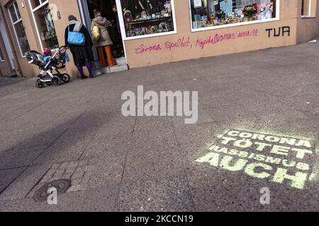 Graffiti reading 'Corona divides, capitalsim too!' and 'Corona kills, racism too' are seen on a wall in Berlin, Germany on April 3, 2021. (Photo by Emmanuele Contini/NurPhoto) Stock Photo