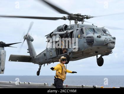 An MH-60S Sea Hawk is cleared for take off from the flight deck of USS Boxer. Stock Photo