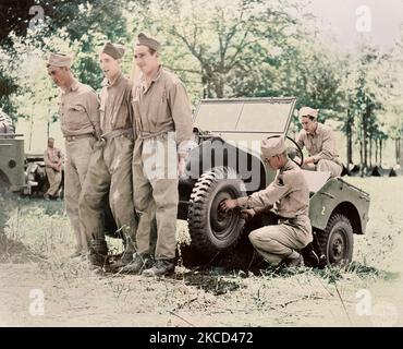 American soldiers lifting a jeep to repair it at their bivouac area, 1941. Stock Photo