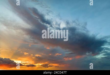 Cumulonimbus clouds forming before thunderstorm on evening sky. Changing stormy cloudscape weather at sunset Stock Photo