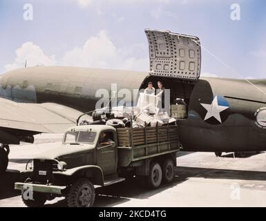 Unloading cargo from a U.S. Army Air Transport Command cargo plane, circa 1943. Stock Photo