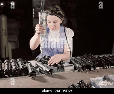 Woman worker using an electric screwdriver to assemble toy trains, 1942. Stock Photo