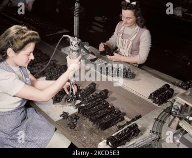 Women workers using an electric screwdriver to assemble toy trains, 1942. Stock Photo