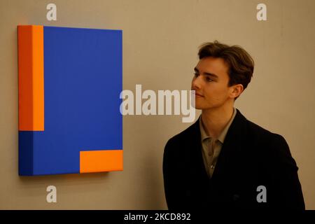 A member of staff poses beside 'Untitled', by Cuban-American artist Carmen Herrera, estimated at GBP150,000-200,000, during a press preview for the upcoming Contemporary Art sale at Bonhams auction house in London, England, on April 22, 2021. The sale takes place on April 27. (Photo by David Cliff/NurPhoto) Stock Photo