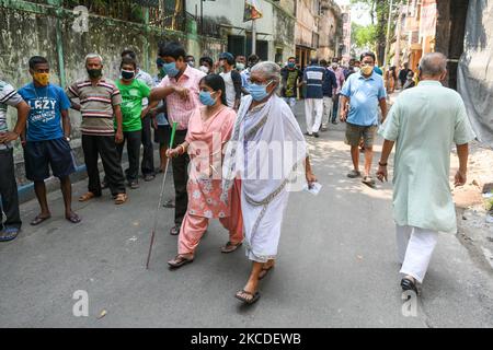 An old lady assist a differently abled girl and boy to caste their vote during 7th phase of West Bengal assembly elections in Kolkata , India , on 26 April 2021 . (Photo by Debarchan Chatterjee/NurPhoto) Stock Photo