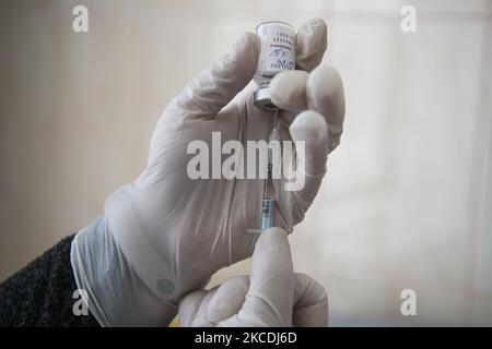 Hands of medical worker in protective gloves removes a dose of AstraZeneca coronavirus vaccine from a vial at a hospital in Kyiv, Ukraine on April 28, 2021. (Photo by Maxym Marusenko/NurPhoto) Stock Photo