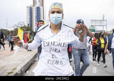 A protester wearing a face mask holds a sign during the national strike against the tax reform proposed by Duque's administration on April 28, 2021 in Bogota, Colombia. (Photo by David Rodriguez/NurPhoto) Stock Photo