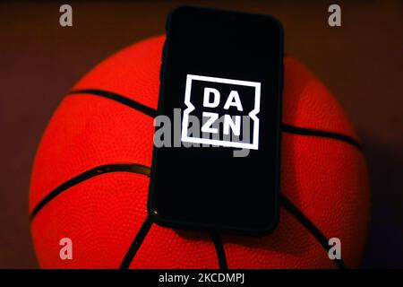 DAZN logo displayed on a phone screen and a basketball are seen this illustration photo taken in Krakow, Poland on April 30, 2021. (Photo by Jakub Porzycki/NurPhoto) Stock Photo