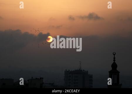 The sun rises over Gaza City amid a flare-up of Israeli-Palestinian violence, May 11, 2021. (Photo by Majdi Fathi/NurPhoto) Stock Photo