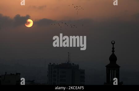 The sun rises over Gaza City amid a flare-up of Israeli-Palestinian violence, May 11, 2021. (Photo by Majdi Fathi/NurPhoto) Stock Photo