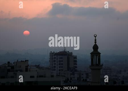 The sun rises over Gaza City amid a flare-up of Israeli-Palestinian violence, May 11, 2021. (Photo by Majdi Fathi/NurPhoto) Stock Photo