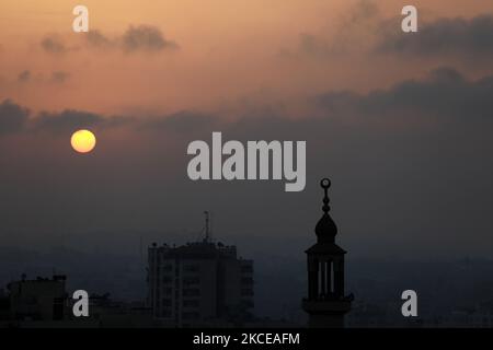 The sun rises over Gaza City amid a flare-up of Israeli-Palestinian violence, May 11, 2021. (Photo by Majdi Fathi/NurPhoto) Stock Photo