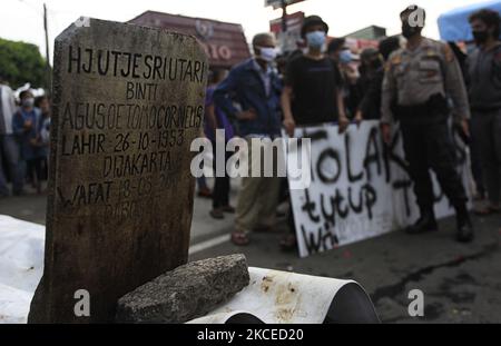 Residents hold placards as they take part in a rally against the closure cemeteries for pilgrimage during celebrate Eid al-Fitr in Bogor, Indonesia, May 12, 2021. after the Governor of Jakarta and Regional heads in the suburbs of Jakarta (Jabodetabek) closed all cemeteries from May 12 - 16, 2021 for pilgrimage to anticipate a surge in crowd that could risk new virus infections (Photo by Adriana Adie/NurPhoto) Stock Photo