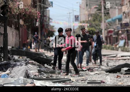 A Palestinian man walks at the rubble of the severely damaged Al-Jawhara Tower in Gaza City on May 12, 2021 after it was hit by Israeli airstrikes amid the escalating flare-up of Israeli-Palestinian violence. The Health Ministry in the Hamas-run Gaza Strip said the number of Palestinians killed has risen to 35, including 12 children, while 233 people were reported injured. (Photo by Momen Faiz/NurPhoto) Stock Photo