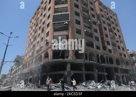 A Palestinian man walks at the rubble of the severely damaged Al-Jawhara Tower in Gaza City on May 12, 2021 after it was hit by Israeli airstrikes amid the escalating flare-up of Israeli-Palestinian violence. The Health Ministry in the Hamas-run Gaza Strip said the number of Palestinians killed has risen to 35, including 12 children, while 233 people were reported injured. (Photo by Momen Faiz/NurPhoto) Stock Photo