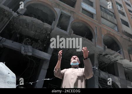 A Palestinian man walks at the rubble of the severely damaged Al-Jawhara Tower in Gaza City on May 12, 2021 after it was hit by Israeli airstrikes amid the escalating flare-up of Israeli-Palestinian violence. The Health Ministry in the Hamas-run Gaza Strip said the number of Palestinians killed has risen to 35, including 12 children, while 233 people were reported injured. (Photo by Momen Faiz/NurPhoto) Stock Photo