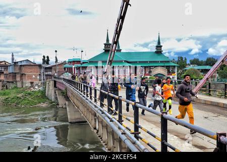 Kashmiri Muslim boys run after being chased by Jammu and Kashmir Police cops after they try to throw stones at the security forces during Muslim festival of Eid-Ul-Fitr amid COVID-19 Coronavirus pandemic in Sopore, District Baramulla, Jammu and Kashmir, India on 13 May 2021. Eid-ul-Fitr celebrations in Kashmir were a low-key affair on Thursday as the faithful marked the culmination of the fasting month of Ramzan by offering the thanksgiving prayers in small congregations at local mosques by observing social distancing in view of the COVID-19 pandemic. No Eid prayers were offered for the fourth Stock Photo