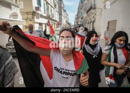 Female protesters wearing the Palestinian flag shout anti-Israel slogans during a march held on the street in the capital Tunis, Tunisia, on May 15, 2021, in support with the Palestinian people and to protest against the Israel's air strikes on Gaza strip and against the Israeli violations in the occupied territories in Palestine, especially in the Palestinian neighborhood in East Jerusalem, Sheikh Jarrah. (Photo by Chedly Ben Ibrahim/NurPhoto) Stock Photo