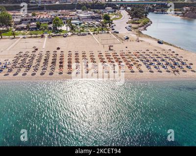 Greece opens for tourism since May 14 and the country is ready to receive the first tourism wave keeping all the COVID protocols in action. The country began easing the lockdown and curfew measures, opened the shops, bars and restaurants with strict rules. Aerial bird's eye panoramic view from a drone of beaches around the villages of Halkidiki area. The beach with the golden sand and transparent crystal-clear emerald water, exotic style just in front of the houses of Pefkohori and Potidea, typical for the Aegean Sea and the Mediterranean. Chalkidiki has a long coastline and is a popular desti Stock Photo