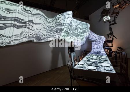 LONDON, UNITED KINGDOM - MAY 18: (EMBARGOED FOR PUBLICATION UNTIL 1800 UK TIME ON 18 MAY 2021) A staff member looks at 'Reimagining the Tea-Party' installation during a photocall for the upcoming exhibition 'Alice: Curiouser and Curiouser' supported by HTC VIVE Arts at the V&A (22 May - 31 December 2021), on 18 May, 2021 in London, England. The V&A’s landmark exhibition in 2021, Alice: Curiouser and Curiouser was designed by award-winning designer Tom Piper and features over 300 objects, spanning film, performance, fashion, art, music and photography to explore the cultural impact of Alice in  Stock Photo