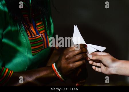 Sadhbh, a little girl with a paper dove meets Salome Mbugua, Kenyan activist and human rights defender inside EPIC The Irish Emigration Museum in Dublin on Wednesday, May 19, as part of Herstory's new Parallel Peace Project, launched on World Cultural Diversity Day for Dialogue and Development. Syrian, Somali, Kenyan, Libyan activists took part in a project in Dublin that tells the story of women and girls on the island of Ireland whose lives have been hit by wars and social conflicts. On Thursday, 20 May 2021, in Dublin, Ireland. (Photo by Artur Widak/NurPhoto) Stock Photo