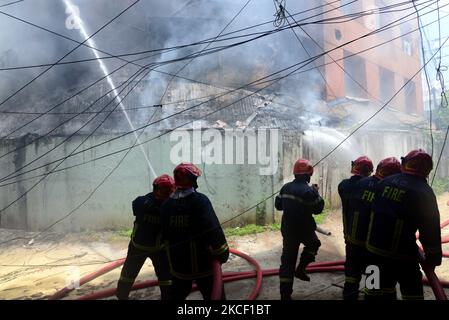 Firefighters try to extinguish a fire that broke out in a clothing ...