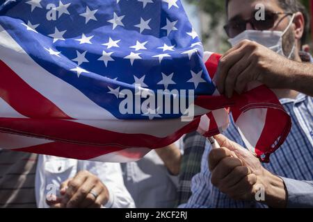 Iranian protesters burn the U.S. flag during a gathering in support of Palestinian people, at the Palestine square in central Tehran, on May 22, 2021. A group of Iranian men and women have gathered at the Palestine square to celebrate the Victory of the Palestinians over Israel, according to the statement that has been read by a protester. (Photo by Morteza Nikoubazl/NurPhoto) Stock Photo