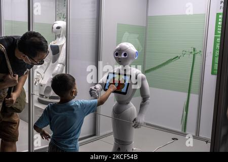 Visitors interacting with a Robot on display at the “Robots, The 500-Year Quest to Make Machines Human' in the Hong Kong Science Museum, in Hong Kong, China on May 22, 2021. (Photo by Vernon Yuen/NurPhoto) Stock Photo