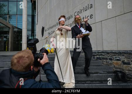 Extinction Rebellion activists, Ceara Carney dresses blindfolded in a gown as Lady Justice and Louis Heath wearing a suit to represent the state seen during a theatrical protest on the steps of the Criminal Court of Justice in Dublin to show the injustice of climate inaction as 20-year-old Orla Murphy, a climate activist, appears in court for criminal damages. On Tuesday, May 25, 2021, in Dublin, Ireland. (Photo by Artur Widak/NurPhoto) Stock Photo