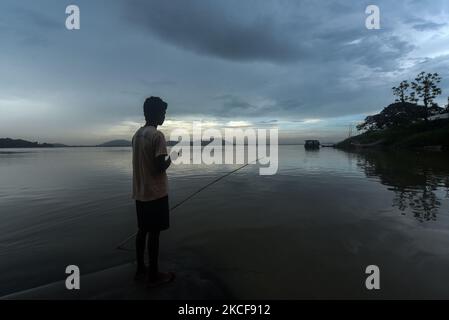 A boy fishing at the Brahmaputra river during a cloudy day, in Guwahati, Assam, India on 26 May 2021. Assam and other parts of the Northeast India are expected to receive rainfall due to the cyclone Yaas. (Photo by David Talukdar/NurPhoto) Stock Photo