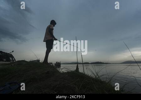A boy fishing at the Brahmaputra river during a cloudy day, in Guwahati, Assam, India on 26 May 2021. Assam and other parts of the Northeast India are expected to receive rainfall due to the cyclone Yaas. (Photo by David Talukdar/NurPhoto) Stock Photo
