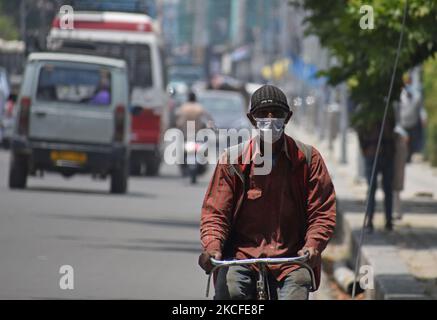 A man cycles in Srinagar, Kashmir, India on May 31, 2021.The Jammu and Kashmir Government has eased the Covid-19 restrictions after a month since they were imposed to stop further spread of the Covid-19 Coronavirus infection.As per the guidelines bussiness establishments ,offices malls and public transport will be allowed to operate on weekdays. (Photo by Faisal Khan/NurPhoto) Stock Photo