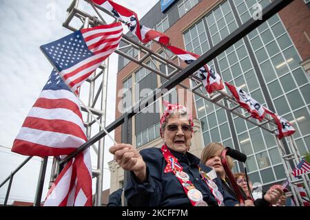 A parade participant waves the American flag from atop a float as residents of Royal Oak, Michigan line the streets of downtown on May 31, 2021 to view the Memorial Day Parade, an American tradition honoring fallen soldiers that originated in the years following the Civil War. (Photo by Adam J. Dewey/NurPhoto) Stock Photo