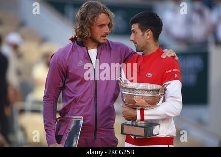 Runner-up Stefanos Tsitsipas of Greece is consoled by winner Novak Djokovic of Serbia as they hold their respective trophies on the podium after the Men's Singles Final match during Day Fifteen of the 2021 French Open at Roland Garros on June 13, 2021 in Paris, France. (Photo by Mehdi Taamallah/NurPhoto) Stock Photo