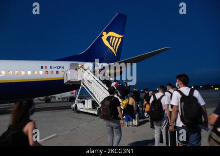 Passengers are seen boarding on a Boeing 737-800 aircraft with registration EI-EFN of Ryanair, the Irish Low Cost Airline Carrier at Chania Airport CHQ in Crete Island in Greece after the sunset. Travelers need to have prove of vaccination or Covid-19 Coronavirus negative test and wear a mandatory face mask, a measure because of the pandemic. Crete is a popular holiday destination. Chania, Greece on June 13, 2021 (Photo by Nicolas Economou/NurPhoto) Stock Photo