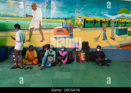 People wearing mask to waits to board a train in front a mural of Mahatma Gandhi at a railway station in Kolkata, India, on 15 June 2021. India recorded above 60,000 cases, countries lowest record in 2 months according to Indian media report. (Photo by Debarchan Chatterjee/NurPhoto) Stock Photo