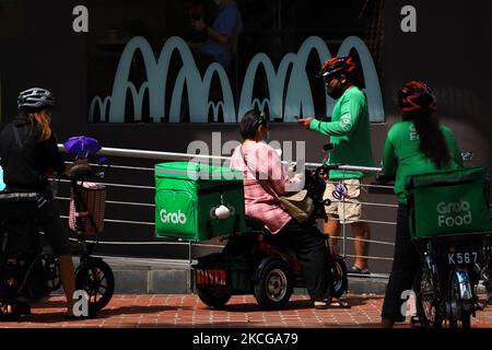 GrabFood delivery riders are seen waiting outside a McDonald’s restaurant on June 21, 2021 in Singapore. McDonald’s Singapore launches the BTS meal today after a three weeks delay due to a resurgent in COVID-19 cases. To prevent long queues amid the COVID-19 pandemic, the BTS meal is only made available on delivery at McDelivery, GrabFood and FoodPanda. The BTS meal, a collaboration between McDonald’s and K-pop supergroup, BTS consists of a box a nine piece Chicken McNuggets, one large-sized fries, one large-sized drink and an exclusive sweet chilli and cajun dipping sauces inspired by popular Stock Photo