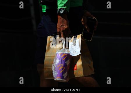 A GrabFood delivery rider is seen carrying a McDonald’s BTS meal on June 21, 2021 in Singapore. McDonald’s Singapore launches the BTS meal today after a three weeks delay due to a resurgent in COVID-19 cases. To prevent long queues amid the COVID-19 pandemic, the BTS meal is only made available on delivery at McDelivery, GrabFood and FoodPanda. The BTS meal, a collaboration between McDonald’s and K-pop supergroup, BTS consists of a box a nine piece Chicken McNuggets, one large-sized fries, one large-sized drink and an exclusive sweet chilli and cajun dipping sauces inspired by popular recipes  Stock Photo