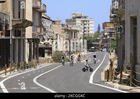 Tourists cycle through an area fenced in by the Turkish military since 1974 in the abandoned coastal area of Varosha, a suburb of the city of Famagusta in Turkish-controlled northern Cyprus. Saturday, June 26, 2021. (Photo by Danil Shamkin/NurPhoto) Stock Photo