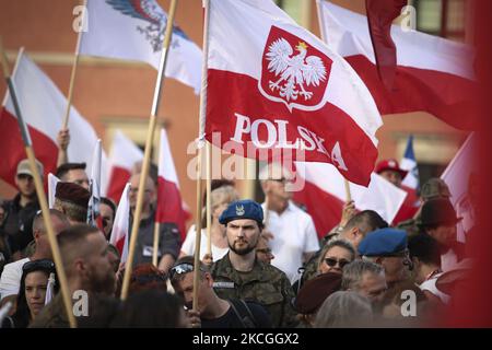 A man in a camouoflage uniform holds a Polish flag during a nationalist rally on 26 June, 2021 in Warsaw, Poland. About a hundred nationalists marched to the Royal Castle in the Old town on Saturday to install a sculpture of the late statesman Roman Dmowski. The late Dmowski is considered an idol by many nationalists in Poland for his ambition to turn the country into a monoethnic state. (Photo by STR/NurPhoto) Stock Photo