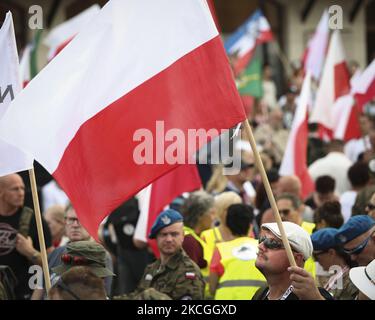 A man holds a Polish flag during a nationalist rally on 26 June, 2021 in Warsaw, Poland. About a hundred nationalists marched to the Royal Castle in the Old town on Saturday to install a sculpture of the late statesman Roman Dmowski. The late Dmowski is considered an idol by many nationalists in Poland for his ambition to turn the country into a monoethnic state. (Photo by STR/NurPhoto) Stock Photo