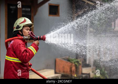 Firefighters from south tangerang spray disinfectant in Pamulang, South Tangerang, Banten, Indonesia on July 1, 2021. The implementation of disinfectants in Indonesia has been increased due to the second wave of Covid-19 attacks with new variants. (Photo by Donal Husni/NurPhoto) Stock Photo