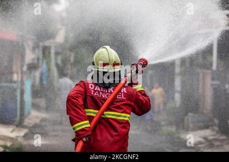 Firefighters from south tangerang spray disinfectant in Pamulang, South Tangerang, Banten, Indonesia on July 1, 2021. The implementation of disinfectants in Indonesia has been increased due to the second wave of Covid-19 attacks with new variants. (Photo by Donal Husni/NurPhoto) Stock Photo