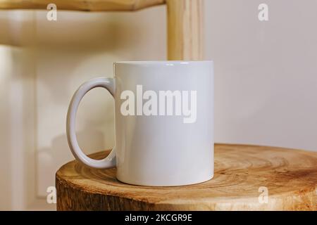 White mug mock-up. Cup standing on the wooden table close-up Stock Photo