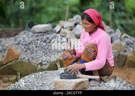 Nepalese woman laborer breaks rocks into gravel with a rubber tool with a wooden handle and a small hammer in Khechuperi, Sikkim, India. the gravel will be used to make cement for construction. (Photo by Creative Touch Imaging Ltd./NurPhoto) Stock Photo