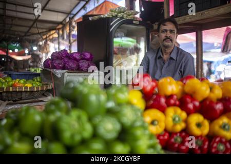 A vegetable seller without wearing a mask is waiting for the customer as there are few customers reached the market on July 6, 2021 in Dhaka, Bangladesh. On 6th July 2021, second-highest in death tolls and highest in new cases(163 deaths with 11,525 new cases) in a day in Bangladesh since the pandemic began. All departments of the law enforcement battalion are implying several legal actions so that general people stay home. In reality, the number of people and vehicles increased a lot. (Photo by Istiak Karim/NurPhoto) Stock Photo