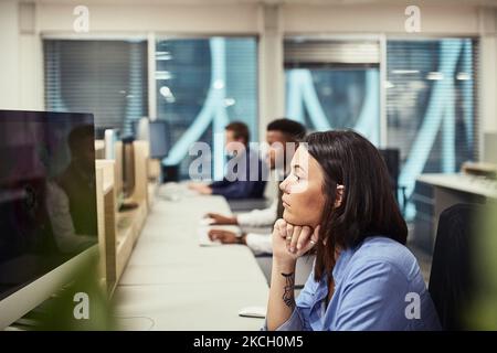 In the creative zone. a group of designers working on computers in an office. Stock Photo